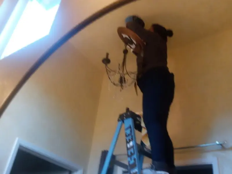Electrician installing a chandelier in a Cicero residence